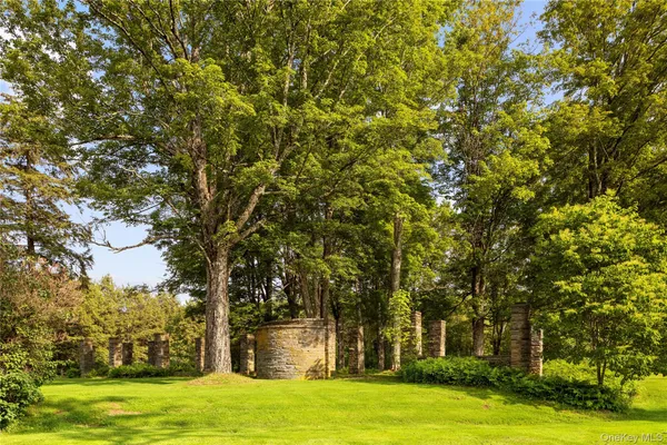a view of a house with a big yard and large trees