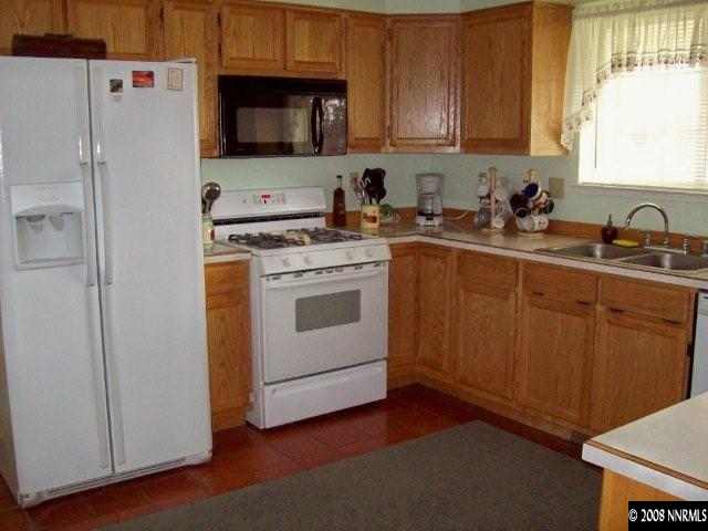 4075 Alcorn Road Fallon, NV 89406 - Photo 5 of 9 a kitchen with a sink stove and refrigerator