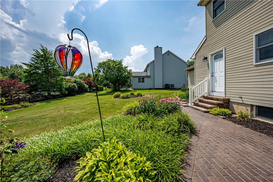 4568 Greenfield Road Bethlehem, PA 18017 - Photo 45 of 59 A neatly laid brick pathway guides toward the home, surrounded by verdant landscaping.