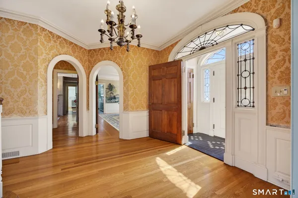 a view of a hallway with wooden floor and staircase