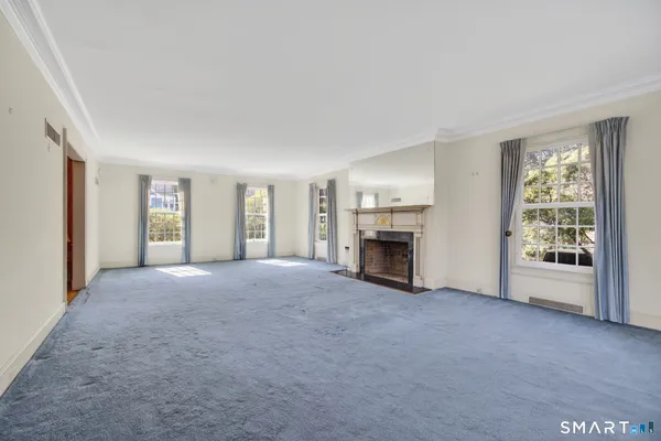 a view of empty room with a fireplace and a window