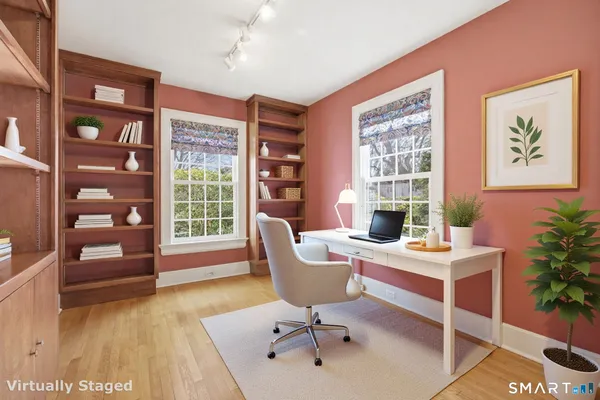 a view of a workspace with furniture and a window
