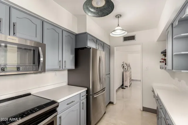 a kitchen with stainless steel appliances a refrigerator and a stove top oven