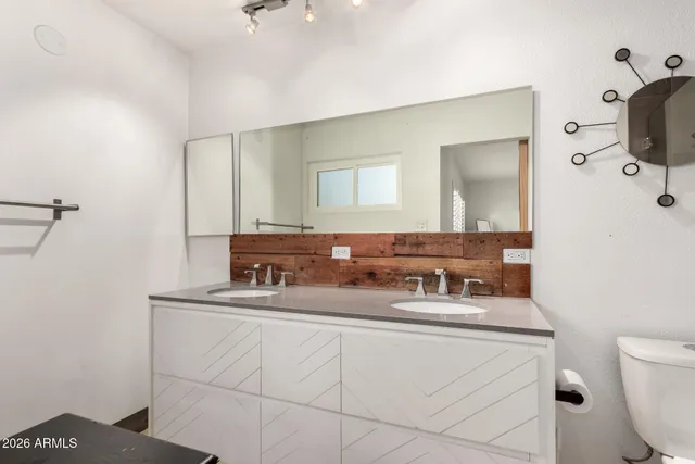 a bathroom with a sink a toilet and mirror