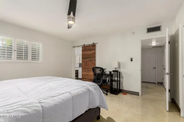 a bedroom with a bed and a refrigerator