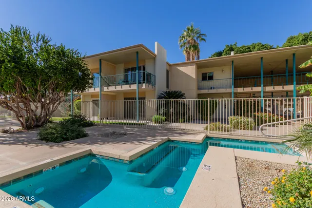 a view of a house with a small yard and wooden fence