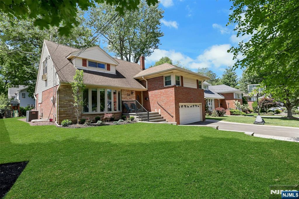 514 Rutland Avenue Teaneck, NJ 07666 - Photo 4 of 40 a front view of a house with a garden and trees