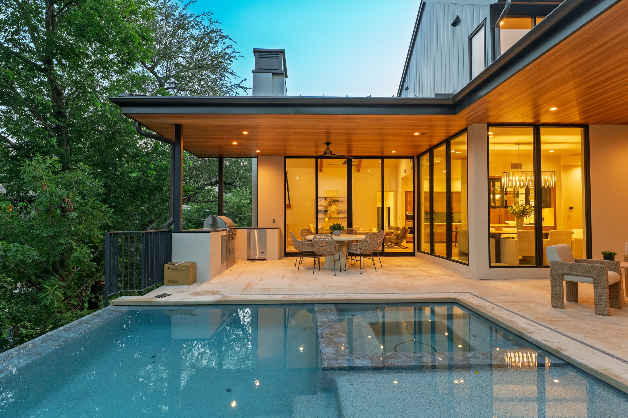 405 Honeycomb Ridge Austin, TX 78746 - Photo 2 of 15 A spacious poolside patio and outdoor kitchen provide an ideal setting for entertaining.