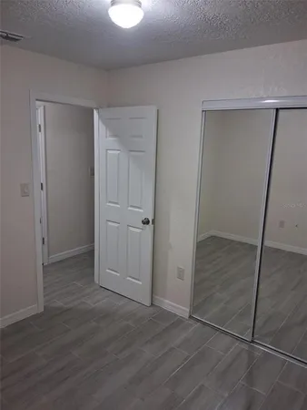 an empty room with wooden floor and closet area