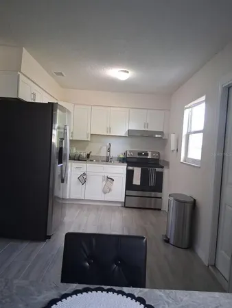 a kitchen with stainless steel appliances granite countertop a refrigerator and a stove top oven