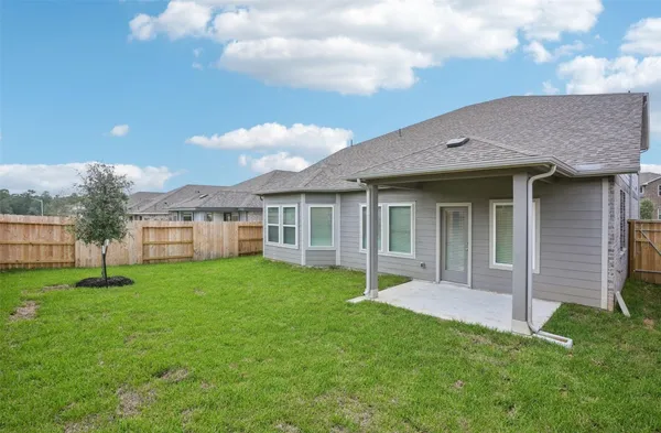 a view of a house with a yard and a large tree