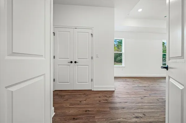 a view of empty room with wooden floor and window