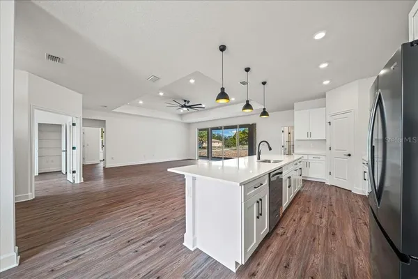 a kitchen with stainless steel appliances a sink a stove and a wooden floors