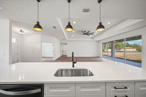 a kitchen with a sink stove and wooden floor