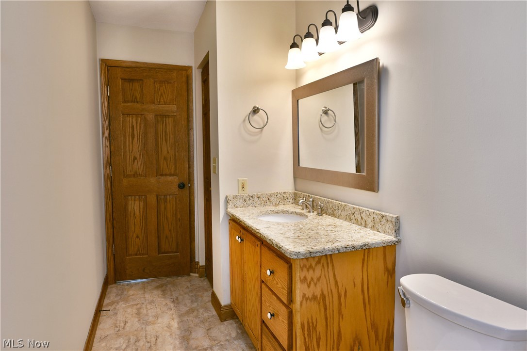 754 Warner Road Hubbard, OH 44425 - Photo 24 of 46 Bathroom featuring a light wood-finish vanity with a light granite-style countertop and integrated sink