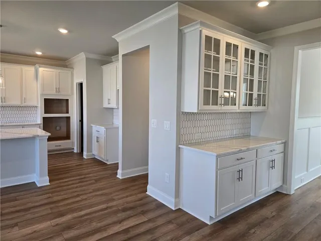 a kitchen with cabinets and wooden floor