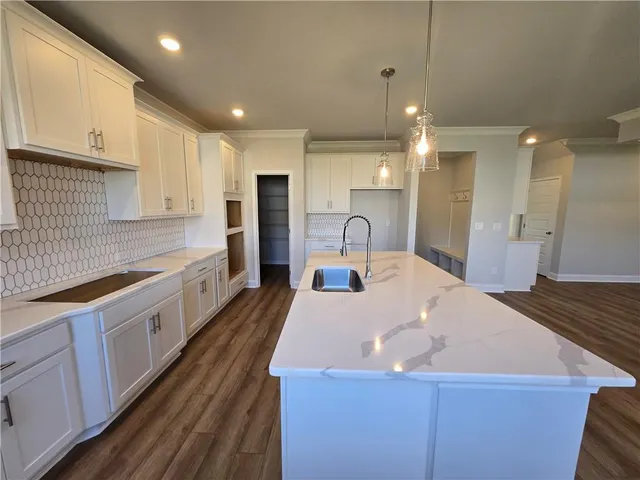 a large kitchen with kitchen island a sink stainless steel appliances and cabinets