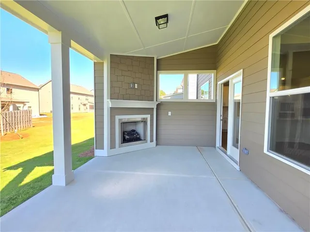 a view of an empty room with window and a fireplace
