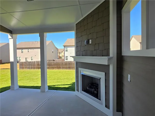 a view of an empty room with a fireplace and a window