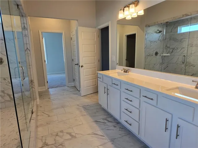 a spacious bathroom with a sink a mirror and a shower