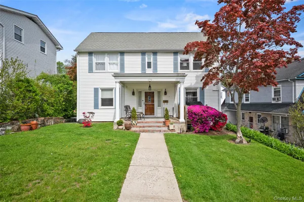 a front view of a house with a garden and plants
