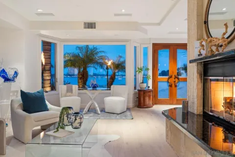 a living room with chairs and a potted plant