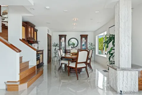 a dining hall with stainless steel appliances kitchen island granite countertop a table chairs and a view of living room