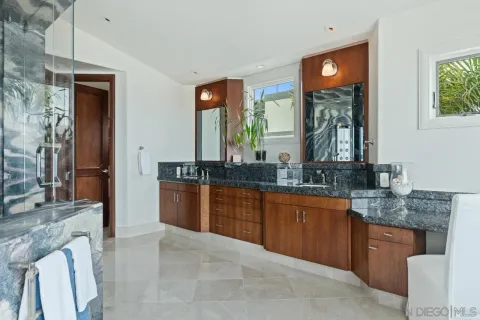 a bathroom with a granite countertop sink a large mirror and a shower