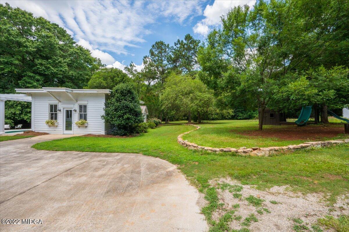 788 Bass Road Macon, GA 31210 - Photo 47 of 71 a view of a white house with a big yard plants and large trees