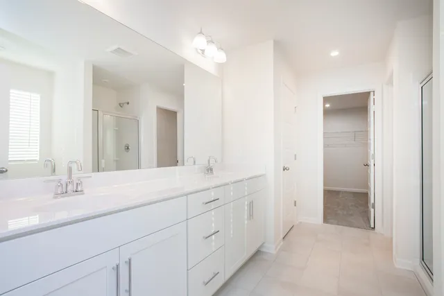 a spacious bathroom with a double vanity sink and a mirror
