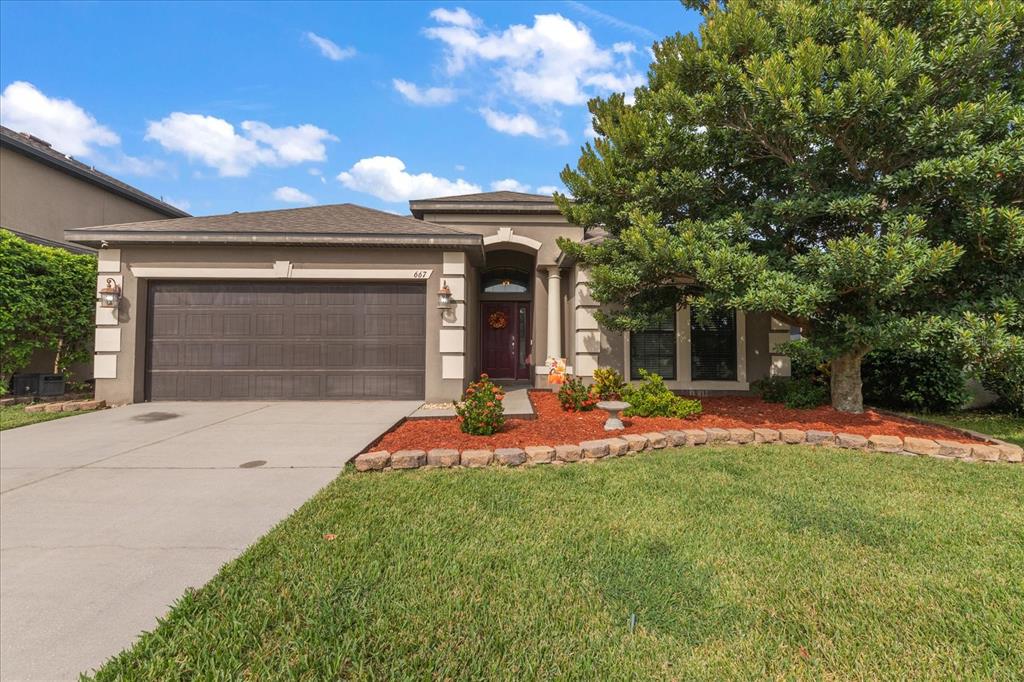 a front view of a house with a yard and garage