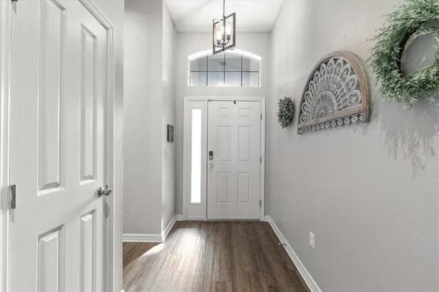 a view of a hallway with wooden floor and entryway