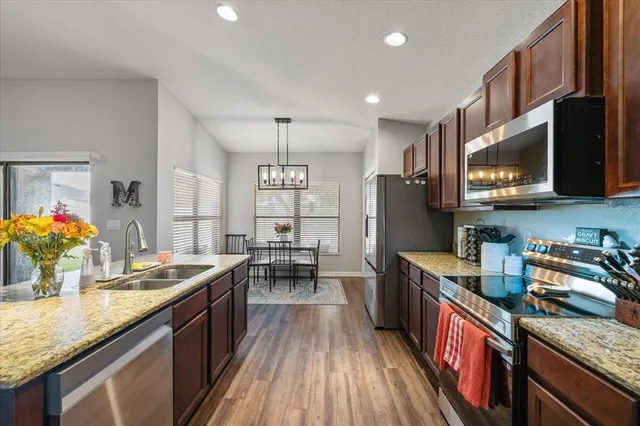 a kitchen with stainless steel appliances granite countertop a sink stove and refrigerator