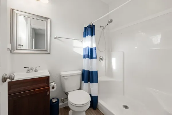 a bathroom with a sink a toilet and shower