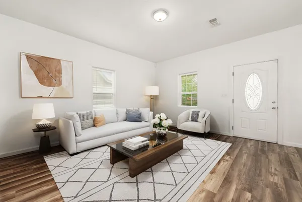 a living room with furniture and wooden floor