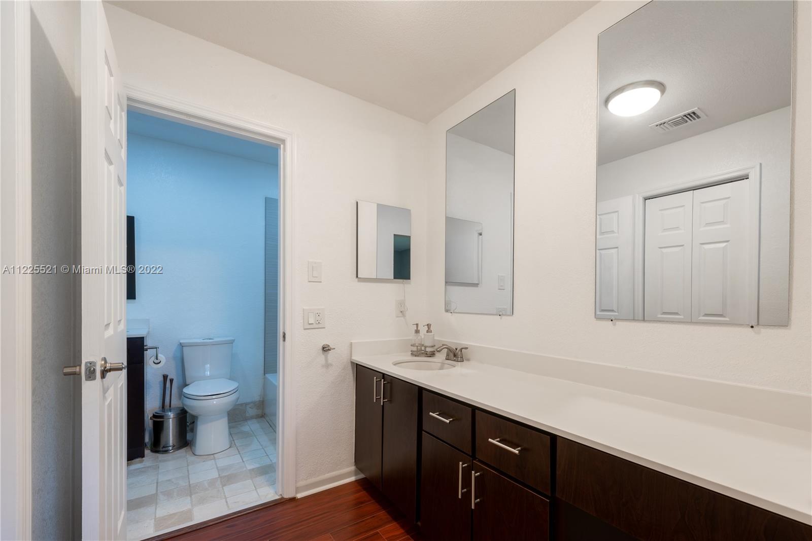 3453 Spring Bluff Place, Unit 12 Lauderhill, FL 33319 - Photo 11 of 20 a bathroom with a sink a toilet a shower and a mirror