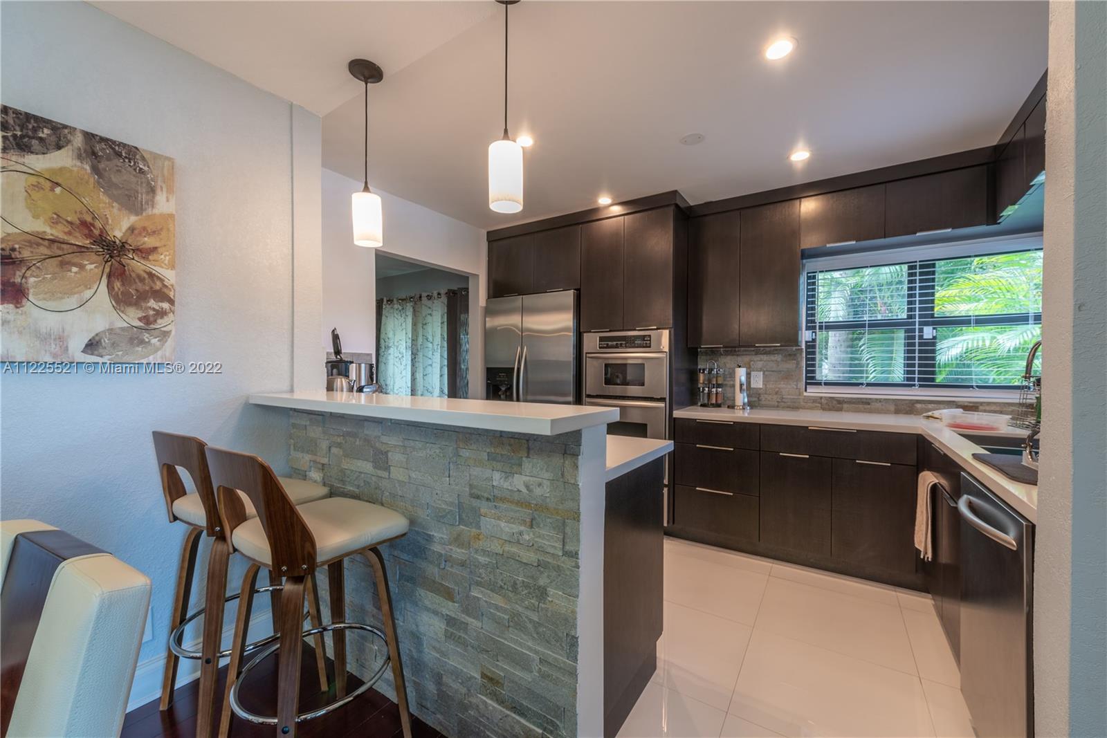 3453 Spring Bluff Place, Unit 12 Lauderhill, FL 33319 - Photo 6 of 20 a kitchen with stainless steel appliances granite countertop a sink and a stove