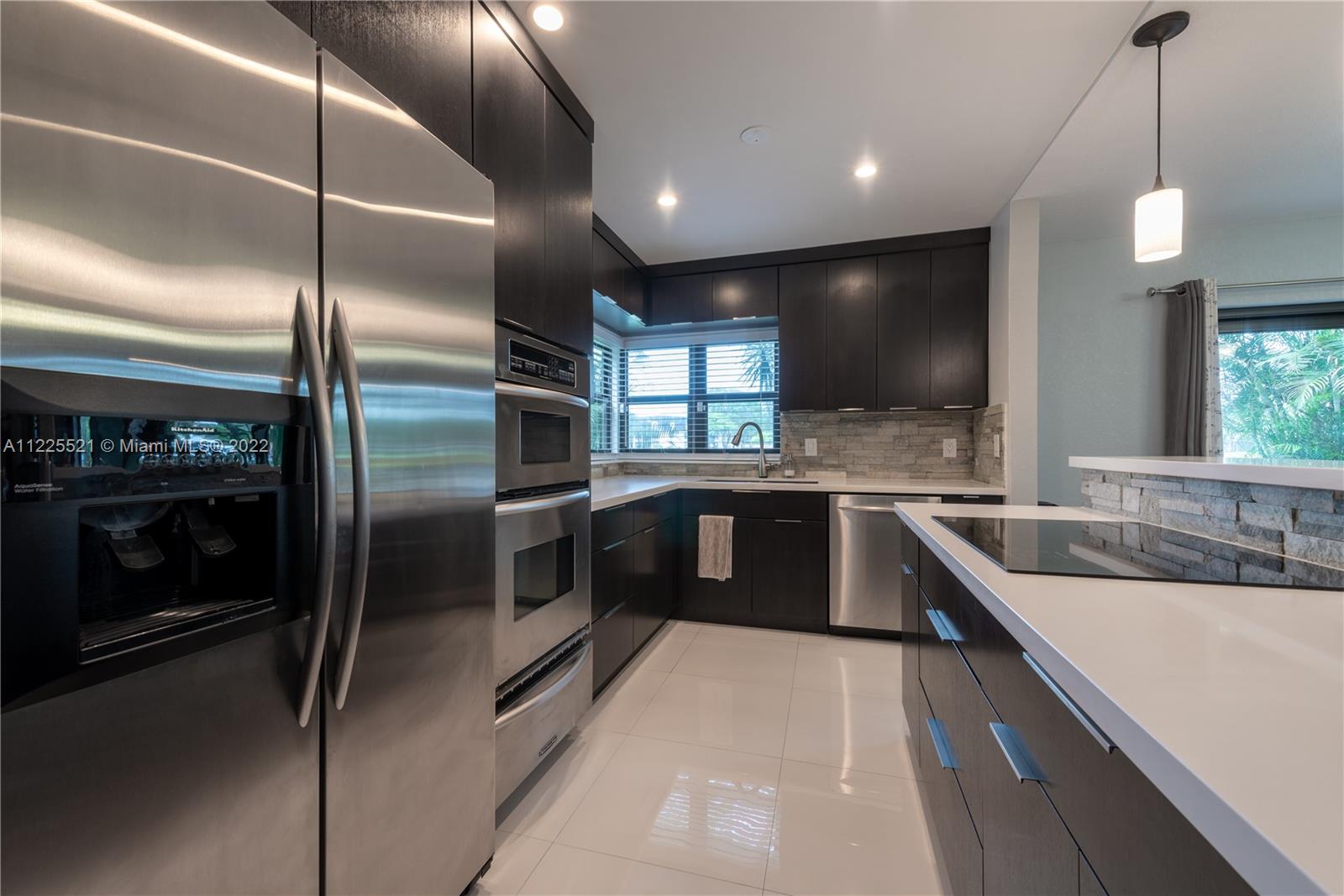 3453 Spring Bluff Place, Unit 12 Lauderhill, FL 33319 - Photo 7 of 20 a large kitchen with a large counter top a sink and stainless steel appliances