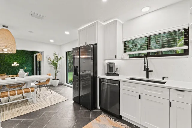 a kitchen with stainless steel appliances a refrigerator a sink a stove and cabinets