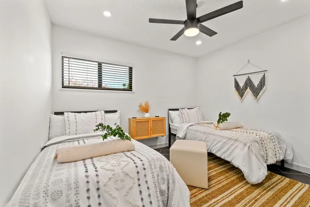 a bedroom with two beds and painting on the wall