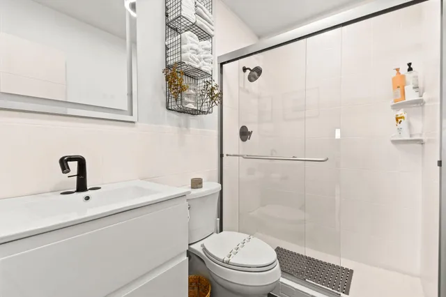 a bathroom with a sink a toilet and shower