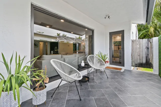 a view of a patio with table and chairs potted plants with wooden floor