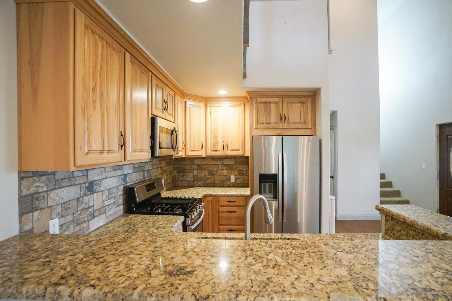 16375 Jesus Maria Road Mokelumne Hill, CA 95245 - Photo 14 of 39 a kitchen with granite countertop a refrigerator and a sink