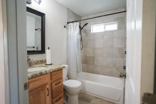 a bathroom with a granite countertop toilet sink and shower