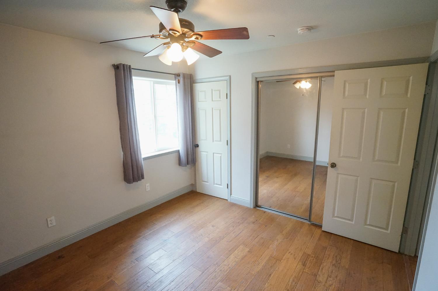 16375 Jesus Maria Road Mokelumne Hill, CA 95245 - Photo 18 of 39 wooden floor in an empty room with a window