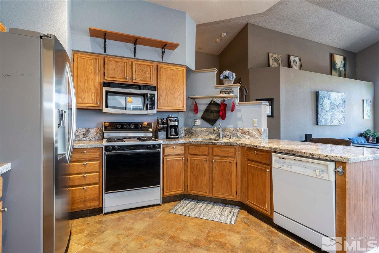 1030 Backer Way Reno, NV 89523 - Photo 9 of 25 a kitchen with stainless steel appliances granite countertop a stove top oven a refrigerator and a cabinets