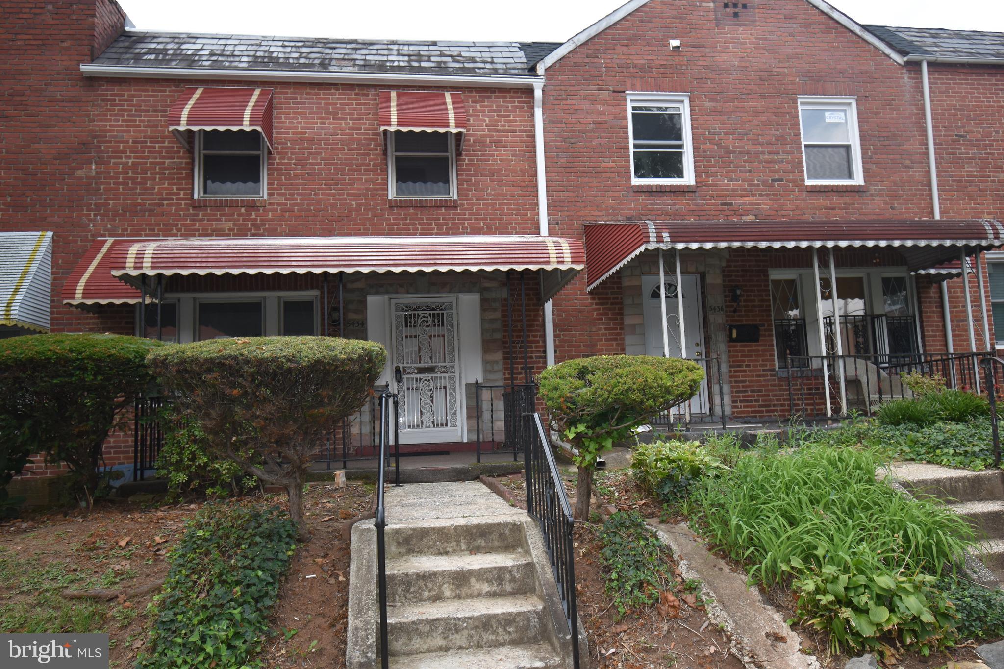 a view of a house with brick walls and a yard with plants