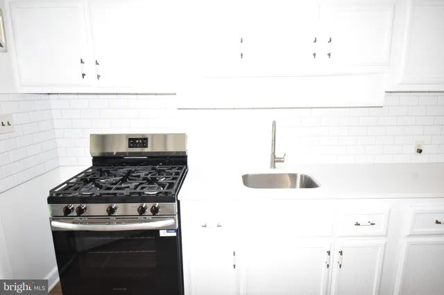 a kitchen with a stove and a white cabinet