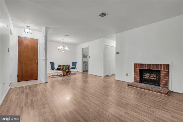 a view of empty room with wooden floor and a fireplace