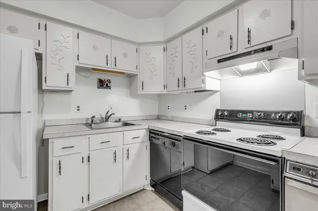 a kitchen with stainless steel appliances a stove a sink and cabinets